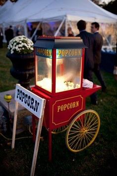 a popcorn cart is sitting in the grass