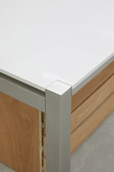 a close up of a white table with wood and metal trim on the top part