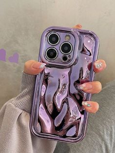 a woman holding up her purple phone case