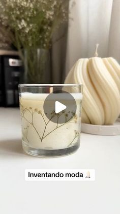 a candle sitting on top of a table next to a vase with flowers in it