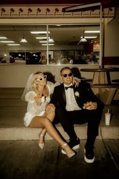 a man and woman sitting on a bench in front of a store