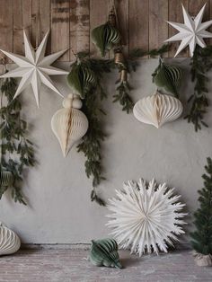 christmas decorations are hanging on the wall next to pine cones and starfish ornament