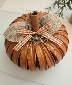 a decorative pumpkin made out of brown paper and burlocks with a ribbon tied around it