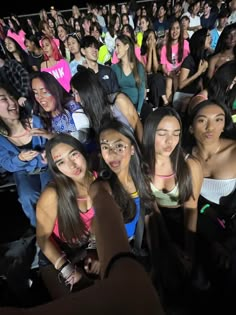 a group of young women standing next to each other in front of an audience at a concert