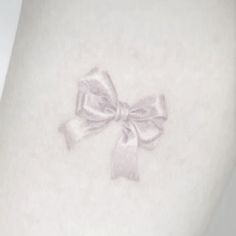 a white tattoo with a bow on it