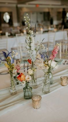 several vases with flowers are sitting on a table