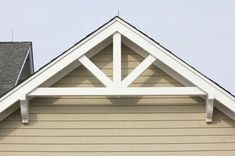 the top of a house with a clock on it's face and two windows