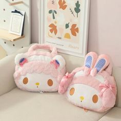 two hello kitty bags sitting on top of a couch next to a stuffed bunny bag