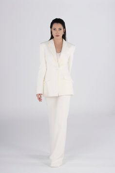 Elevate your wedding style with our Ivory Women's Single Breasted Blazer and Classic Flared Slim Fit High Waist Pant Suit. This bridal ensemble boasts a timeless design, featuring a slim fit, high waist pants, and a single-breasted blazer for a sophisticated and chic look. Whether you're walking down the aisle or celebrating at the ceremony, this elegant suit ensures you stand out with a stylish flair. Experience timeless wedding elegance with this carefully tailored and fashionable bridal outfit. White Pants With Pressed Crease For Formal Occasions, Luxury White Pants For Wedding, Luxury White Wedding Bottoms, Luxury White Evening Pants, Tailored Classic Wedding Pants, Luxury Notch Lapel Wedding Pantsuit, Classic Tailored Pants For Wedding, Luxury Notch Lapel Pantsuit For Wedding, Timeless Wedding Blazer With Pressed Crease