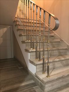 the stairs are made of wood and have metal balustiers on them, along with marble flooring