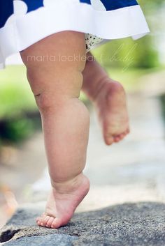 a small child in a blue and white dress is walking