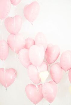 pink heart shaped balloons floating in the air