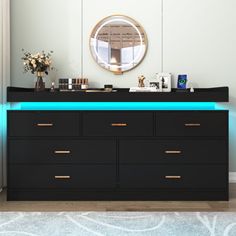 a black dresser with blue lights on it and a mirror in the corner behind it