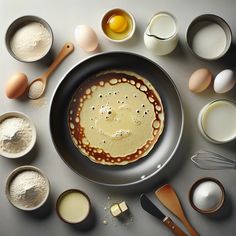 an assortment of ingredients including eggs, flour and butter in bowls on a table top