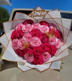 a large bouquet of pink roses in a paper wrapper