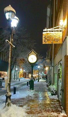 a snowy street at night with snow on the ground and lights in the building windows