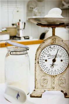 an old fashioned kitchen scale next to a glass jar