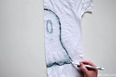 someone is drawing an image on a t - shirt with a pen and paper towel