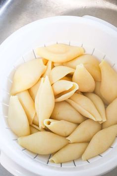 a white bowl filled with uncooked pasta shells