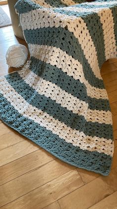 a crocheted blanket is laying on the floor