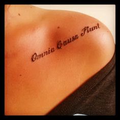 a woman with a tattoo on her shoulder that reads, quinic cause funt