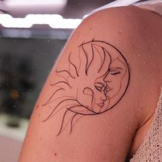 a woman's arm with a sun and moon tattoo design on the left shoulder