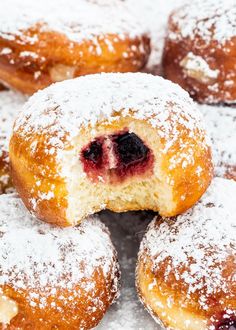 powdered sugar covered donuts with blueberries in the middle