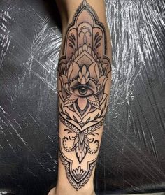 a woman's leg with a hamsa tattoo on it and an eye in the middle