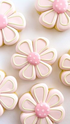 pink and white decorated cookies sitting on top of a table