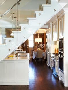 an open kitchen and dining area with stairs leading up to the upper floor in a home