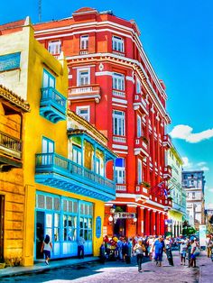 people are walking down the street in front of colorful buildings