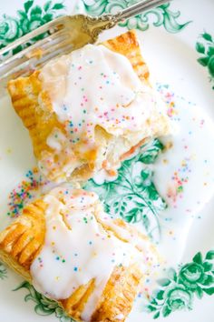 two pieces of pastry with icing and sprinkles are on a plate