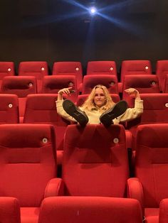 a woman is sitting in an empty theater