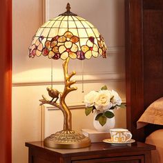 a table with a lamp and flowers on it