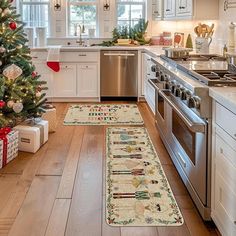 a kitchen decorated for christmas with white cabinets and silver appliances