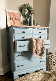 a blue dresser with a blanket on top of it