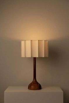 a lamp that is sitting on top of a white block with two lamps in front of it