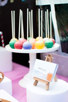 there are many different colored candies on the table and one has a sign in front of it