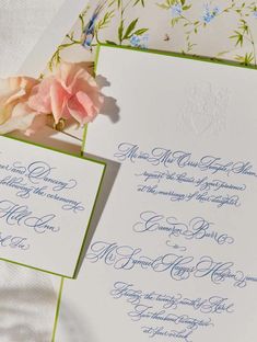 the wedding stationery is laid out on top of each other with flowers in them