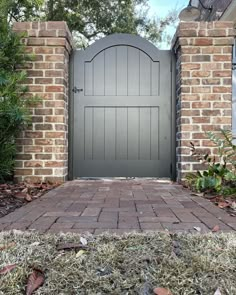 a brick driveway with a large gray gate