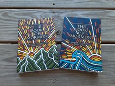 two books sitting on top of a wooden table next to each other with colorful designs