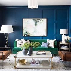 a living room with blue walls and green couches, white rugs on the floor