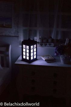 a lamp sitting on top of a table next to a bed in a dark room