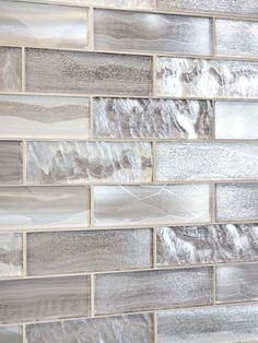 a close up view of a white and gray tile wall with wood grained edges