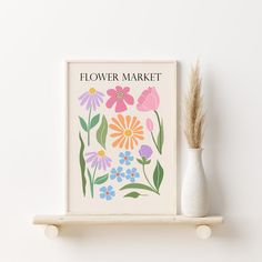 a flower market poster on a shelf next to a vase