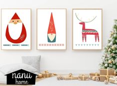 three christmas art prints hanging on the wall next to a small christmas tree and presents