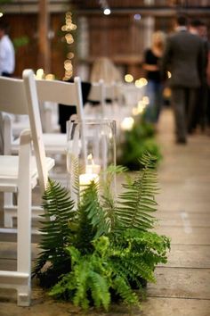 a row of white chairs sitting next to each other on top of a wooden floor