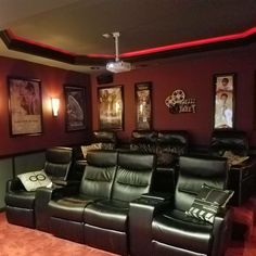 a home theater with leather recliners and pictures on the wall