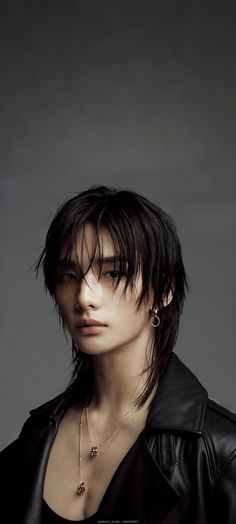 a woman with black hair and piercings wearing a leather jacket is looking at the camera