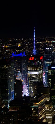 an aerial view of the city at night with skyscrapers lit up in red, white and blue